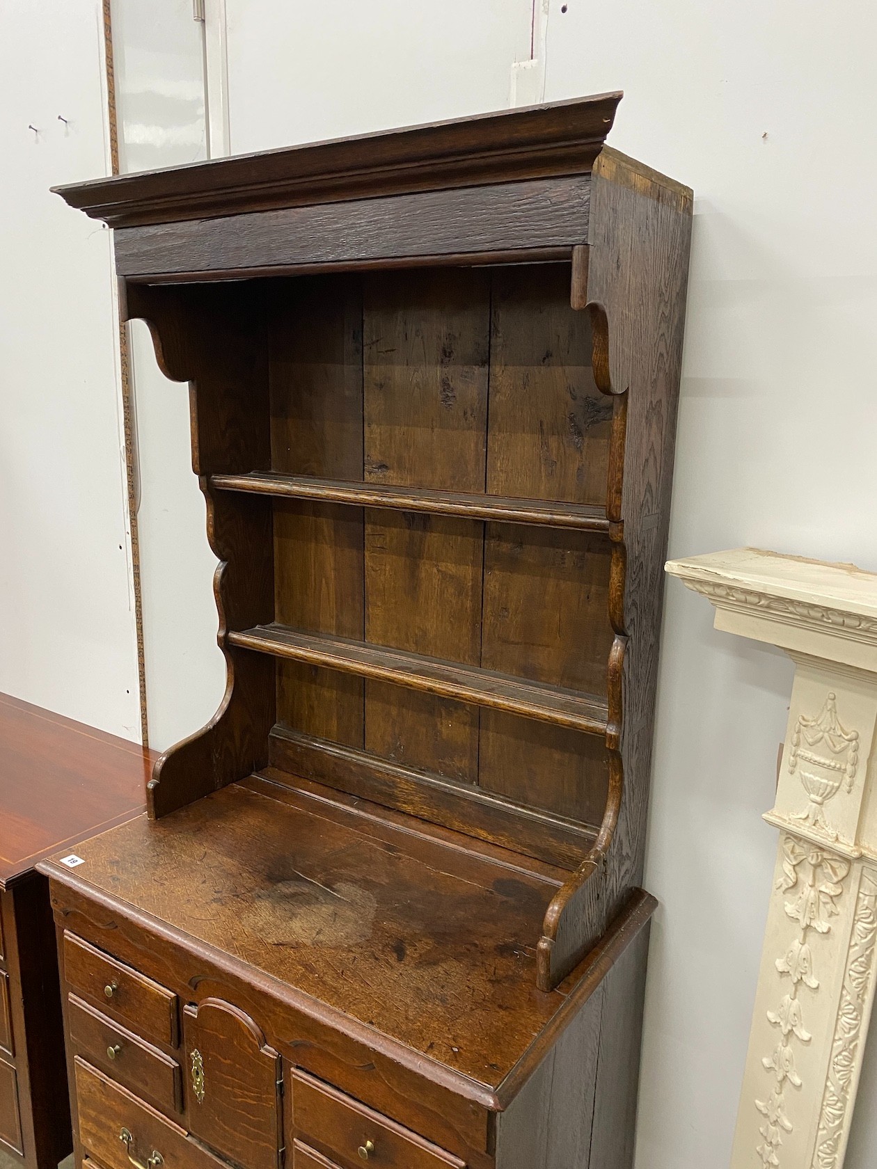 An 18th century oak chest of drawers with later associated oak shelves, width 79cm, depth 46cm, height 188cm